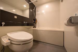 een badkamer met een wit toilet en een bad bij Montein Hotel in Kitakami