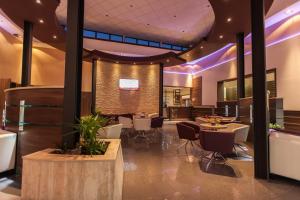 um restaurante com mesas e cadeiras e iluminação roxa em Premium Hotel Panoráma em Siófok