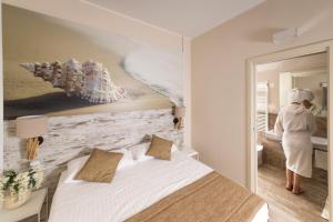 a woman walking into a bedroom with a bed at Hotel Life in Rimini +37 photos