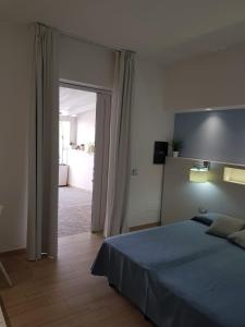 a bedroom with a bed and an open doorway at Hotel Perla Gaia in San Vito lo Capo