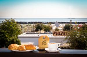 a table with two plates of croissants and a cup of coffee at Hotel Life in Rimini