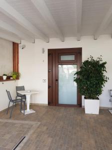 a room with a door and a table and a plant at Hotel Perla Gaia in San Vito lo Capo