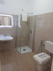 a bathroom with a shower and a toilet and a sink at Hotel Perla Gaia in San Vito lo Capo