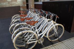uma fila de bicicletas brancas estacionadas uma ao lado da outra em Cosmopolita Hotel Boutique & Spa em Platja d'Aro