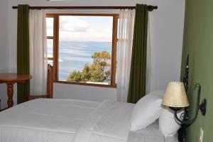 a bedroom with a bed and a large window at Wiñay Inti Lodge in Comunidad Yumani