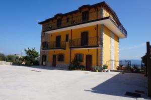 a yellow building with a balcony on top of it at A Casa Di Laura B&B Apartments in Campagna