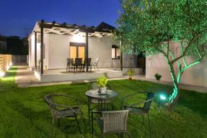 un patio trasero con una mesa y sillas y una casa en Νautilus luxury apartments, en Ierissos