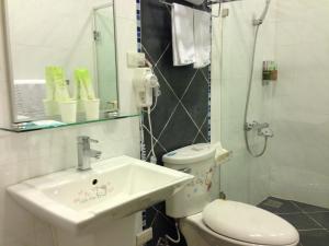 y baño con lavabo, aseo y ducha. en Doll House Lodge, en Hengchun