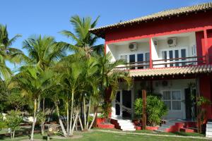 a large white house with trees and palm trees at Pousada Corumbau in Corumbau