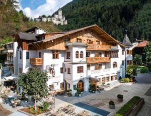 a hotel in the mountains with a castle in the background at Hotel Spanglwirt in Campo Tures