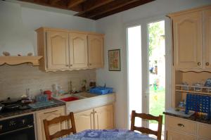 a kitchen with wooden cabinets and a sink and a table at Le Coffret d'avenir in Saint-Denis-en-Val