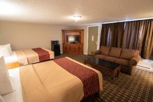Habitación de hotel con 2 camas y sofá en The Crow Peak Lodge en Spearfish