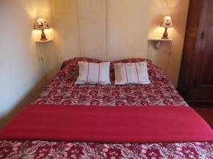 a bedroom with a red bed with two pillows at Arles Bienvenue in Arles