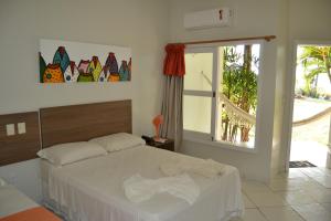 um quarto com uma cama e uma janela em Pousada Corumbau em Corumbau