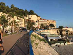 a walkway next to a river with buildings on a hill at Breakfast at Sophy's in Nice