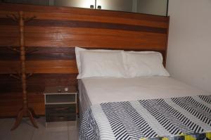 Bett mit einem Kopfteil aus Holz neben einem Tisch in der Unterkunft Flat Winterwille Gravatá in Gravatá + 34 Fotos