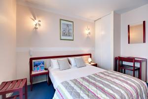pokój hotelowy z łóżkiem i dwoma stołami w obiekcie Hôtel SABLES D'O et son restaurant LE 16 BIS w mieście Les Sables-dʼOlonne