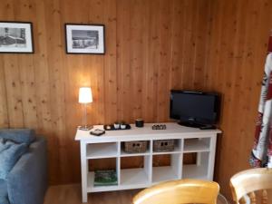 una sala de estar con TV en un armario blanco en Stuga 5 Varmland en Torsby