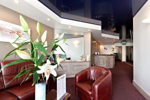a waiting room with a couch and a chair at Hôtel SABLES D'O et son restaurant LE 16 BIS in Les Sables-d'Olonne