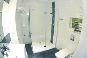 a bathroom with a glass shower with a toilet at Apartamenty Zamkowa in Jelenia Góra