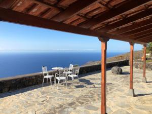 un patio con sillas, una mesa y el océano en Los Torres II, en Fuencaliente de la Palma
