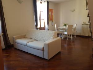 ein Wohnzimmer mit einem weißen Sofa und einem Tisch in der Unterkunft In Piazzetta in Pisa