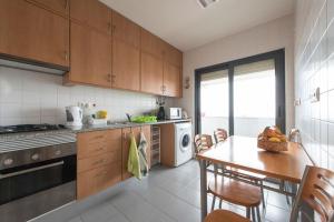 a kitchen with wooden cabinets and a table and chairs at Lovely 3 bedroom for the Perfect stay in Lisbon in Lisbon