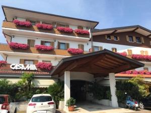 un gran edificio con flores rosas en los balcones en Parc Hotel Casa Mia, en Lazise