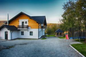 a yellow and white house with a playground at Maramures Landscape in Moisei