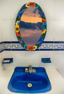 y baño con lavabo azul y espejo. en Hotel Maria's Nicte Ha, en Progreso