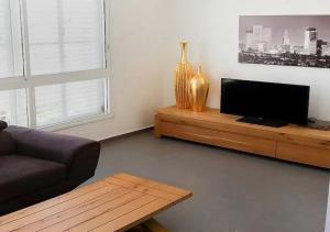 a living room with a couch and a flat screen tv at Oַ&O Group- Cozy APT Bat-Yam 3 Min Walk To Beach in Bat Yam