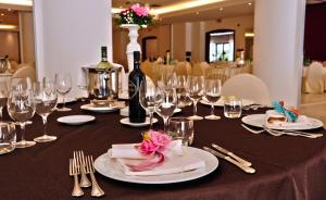 una mesa con copas de vino y botellas de vino. en Grand Hotel Paestum, en Paestum