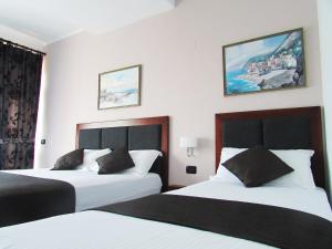 a hotel room with two beds and a painting on the wall at Hotel ANTAG in Shëngjin +17 photos