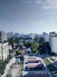 uma vista para uma cidade com um parque de estacionamento e edifícios em Уютная квартира em Kiev