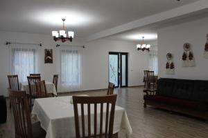 a dining room with a table and chairs and a couch at Maramures Landscape in Moisei