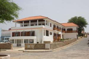 uma casa branca com um telhado vermelho numa rua em Hotel Casa Evora - luxury and beach front em Vila do Maio