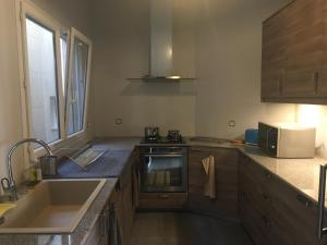 a kitchen with a sink and a stove at Apries de Sais - villa de standing avec piscine in Aogan