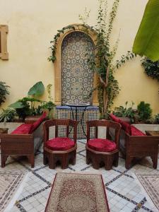 patio z 2 krzesłami i stołem ze stołem w obiekcie Riad Marlinea w mieście Sala