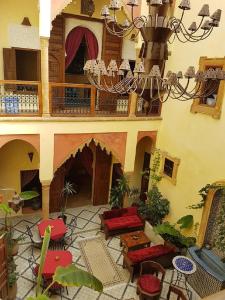 a building with a patio with chairs and a chandelier at Riad Marlinea in Sale