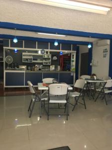 a dining room with tables and chairs and a kitchen at Cabinas Yolymar in Puntarenas