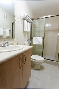 y baño con lavabo, aseo y ducha. en Hotel Coral Suites en Panamá