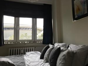 カトヴィツェにあるCosy apartment with amazing viewの窓付きのベッドルームに枕付きのベッド1台