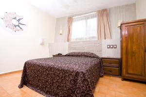 um quarto com uma cama e uma janela em Hotel & Motel Hacienda Jiutepec em Jiutepec