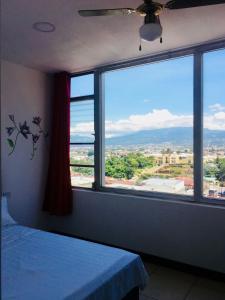 a bedroom with a large window with a view at La Fortuna Roja in San José