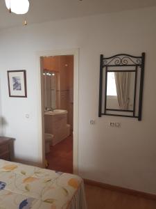 Schlafzimmer mit einem Bett und einem Wandspiegel in der Unterkunft apartamento en Zona nudista in Vera