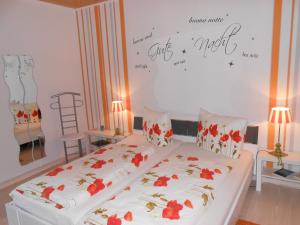 コッヘムにあるHaus Antjeのベッドルーム1室(赤い花のベッド1台付)