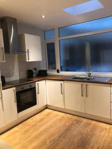 a kitchen with white cabinets and a sink and a window at City Centre apartments in Liverpool