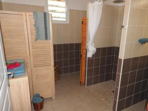 a bathroom with a shower and a shower backdoor at Kreyol Eden Cottage in Le Gosier +24 photos