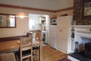 a kitchen with a table and a dining room at Laich Cottage in Appin