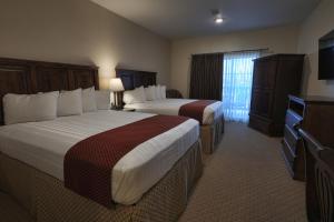 a hotel room with two beds and a television at Arrow Hotel in Broken Bow